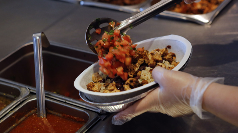 Person filling burrito bowl