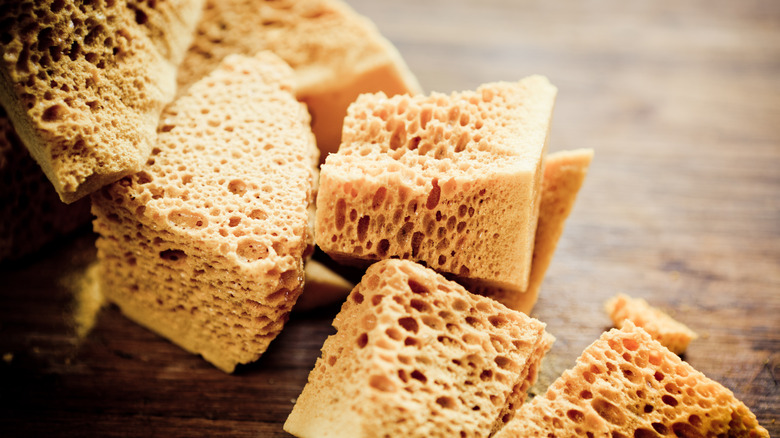 Honeycomb toffee pieces on wooden background