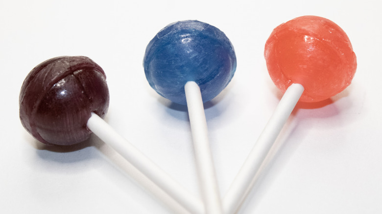 Three round lollipops on sticks on white background