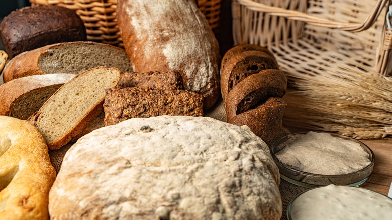 Different bread loaves on a wooden table.