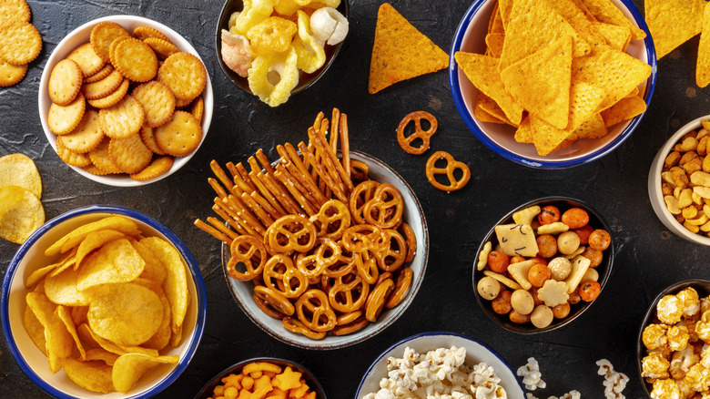 Several bowls each filled with a different type of cracker or chip.