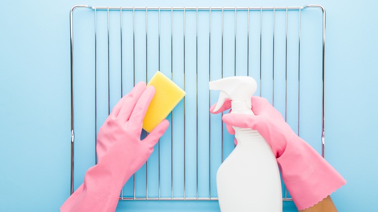 Person cleaning with sponge and bottle