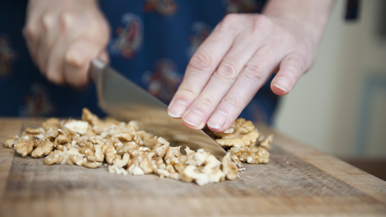 Chopping walnuts on wooden board