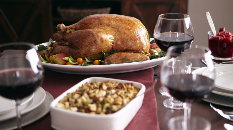 Turkey, stuffing, and glasses of red wine on table