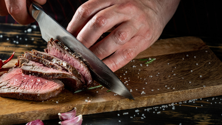 knife slicing steak thinly