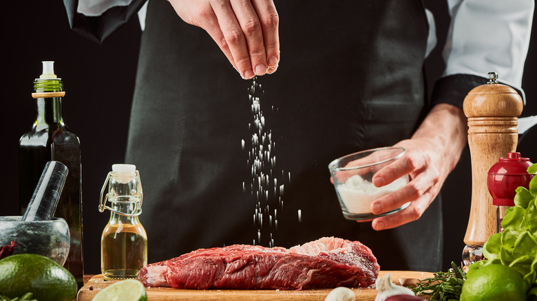 sprinkling salt over raw steak