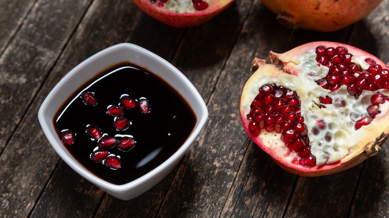 pomegranate molasses next to a fresh pomegranate