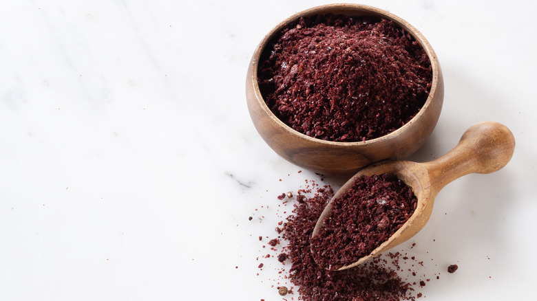 sumac powder in a wooden bowl and spoon