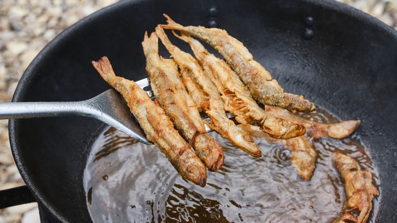 Fried smelt coming out of pan