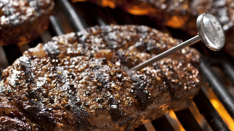 Thermometer in steak on grill