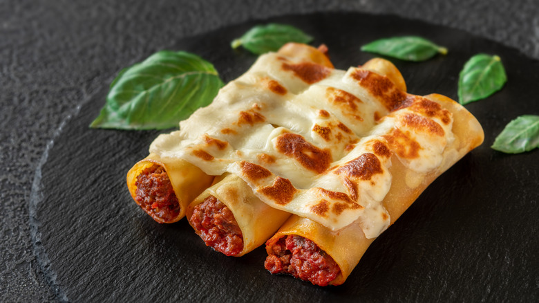 meat-stuffed manicotti on black plate 