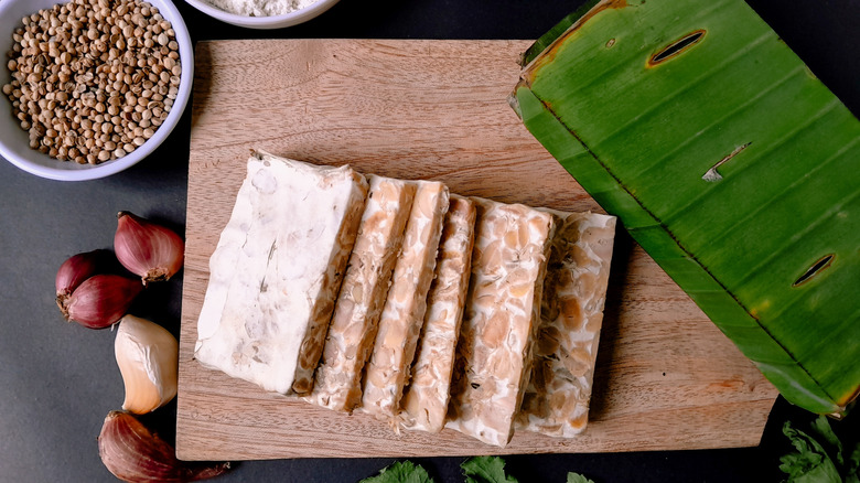 Tempeh on wooden board with ingredients