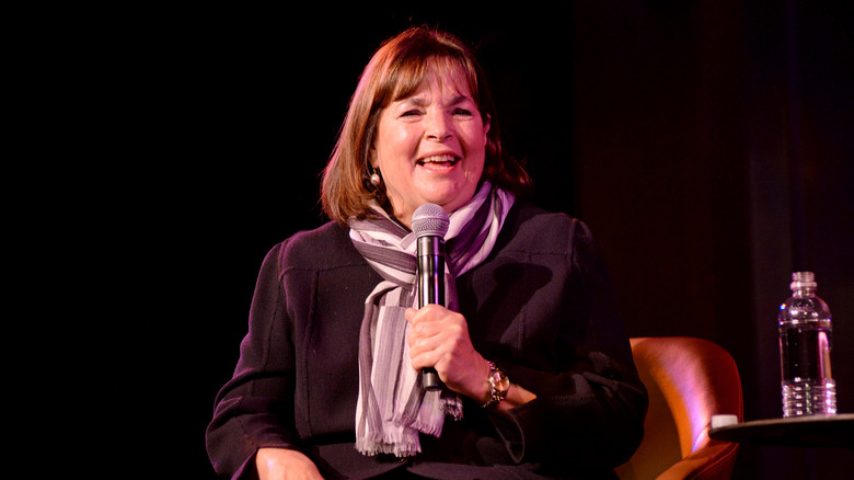 Ina Garten smiling while holding a microphone