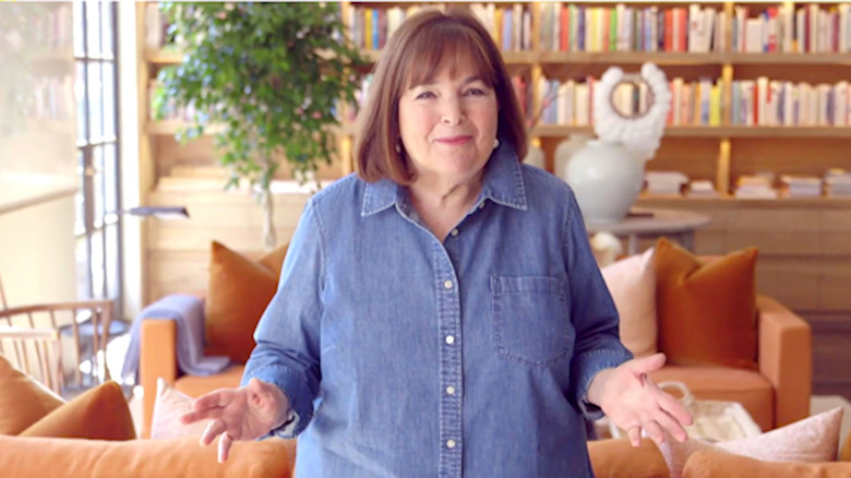Ina Garten smiling and shrugging in blue denim shirt