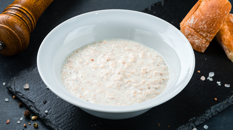 White bowl of plain oatmeal on black slate