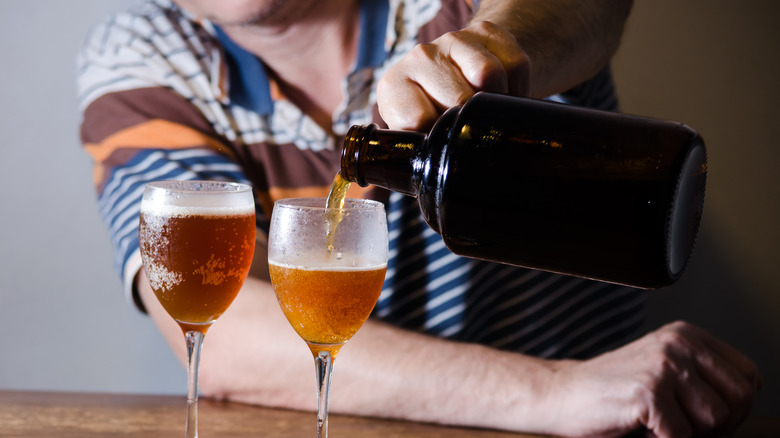 Person filling glasses from beer growler