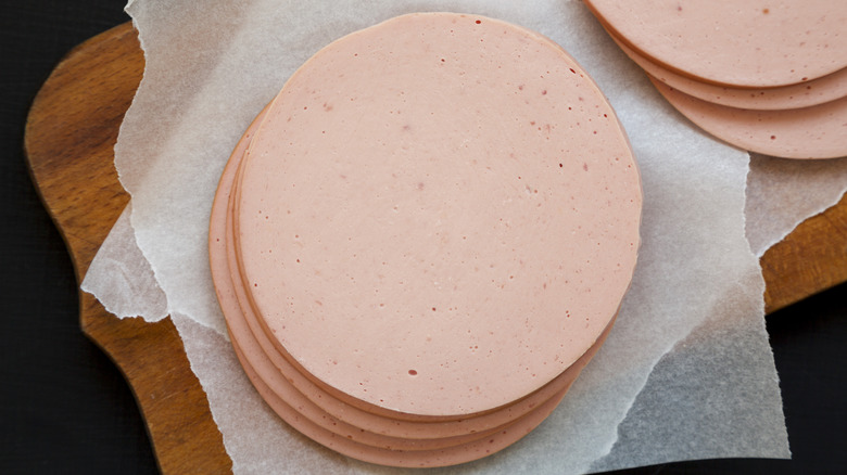 Sliced pork bolgna meat on a rustic wooden board