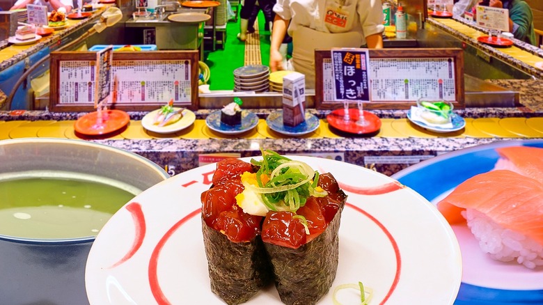 Plates of sushi on a converyor belt at a restaurant