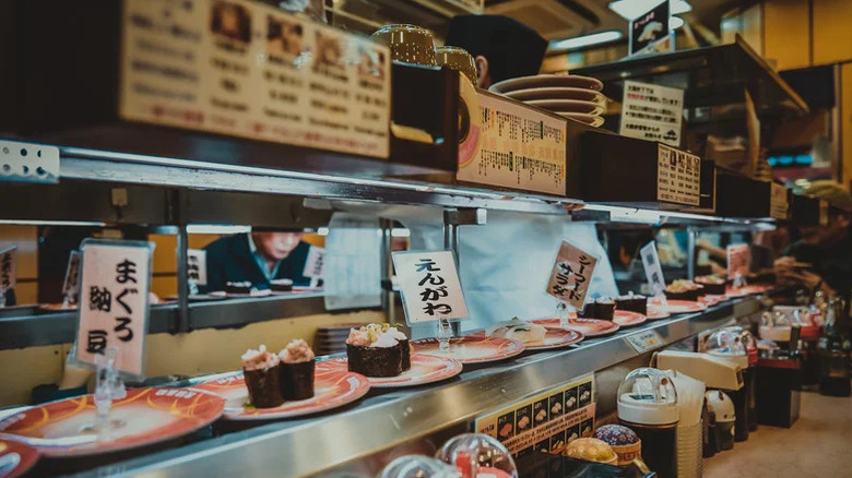 Plates of sushi on conveyor belt at restaurant