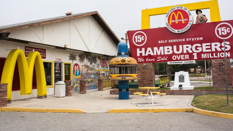 Exterior of original McDonald's location with mascots and signs