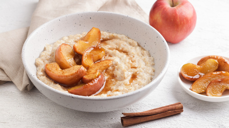 oatmeal in speckled bowl with apples and cinnamon