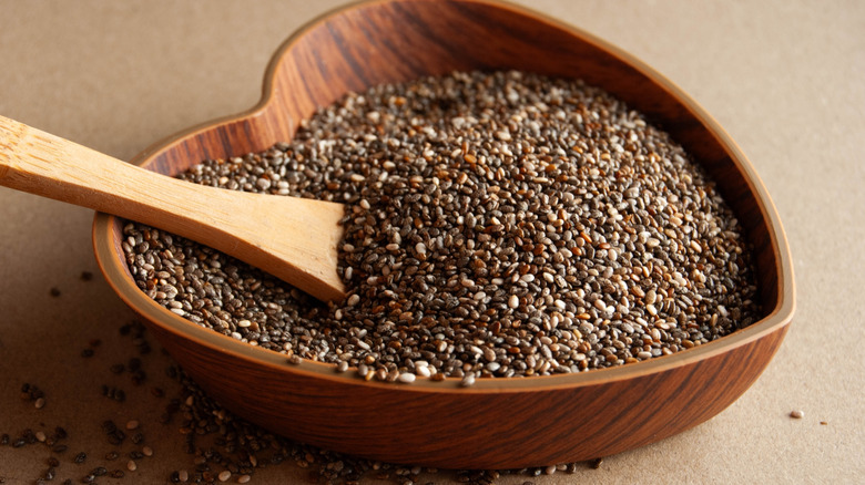 Chia seeds in heart-shaped wooden bowl