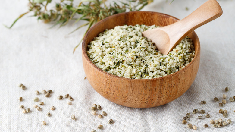 Wooden bowl of shelled hemp seeds with spoon