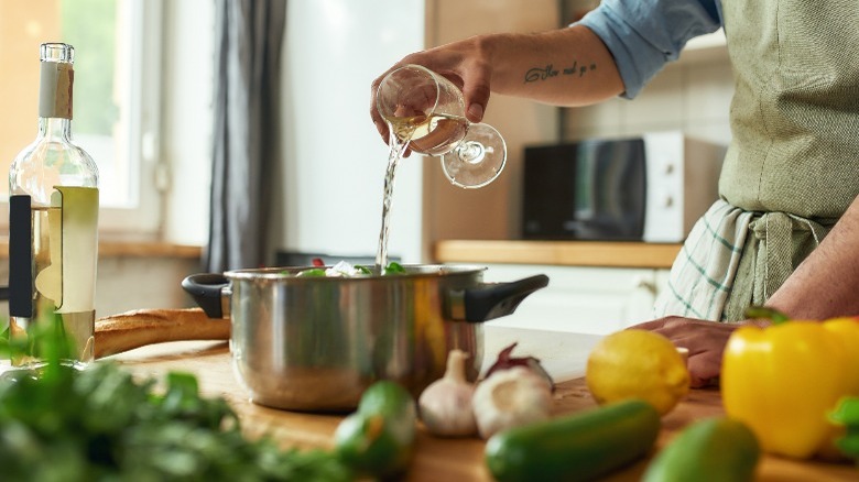 Pouring white wine in pot