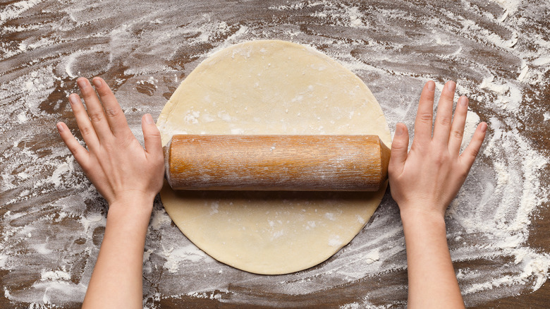 hands rolling out pie crust