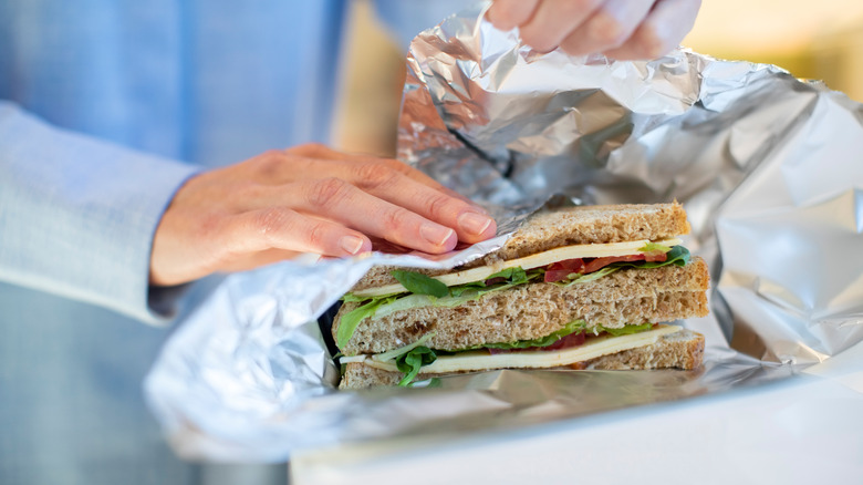 woman wrapping sandwich in foil