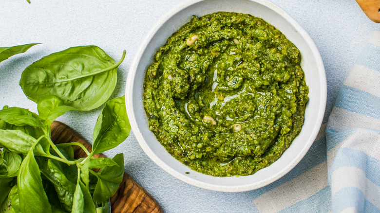 plate of pesto with some fresh basil on the side