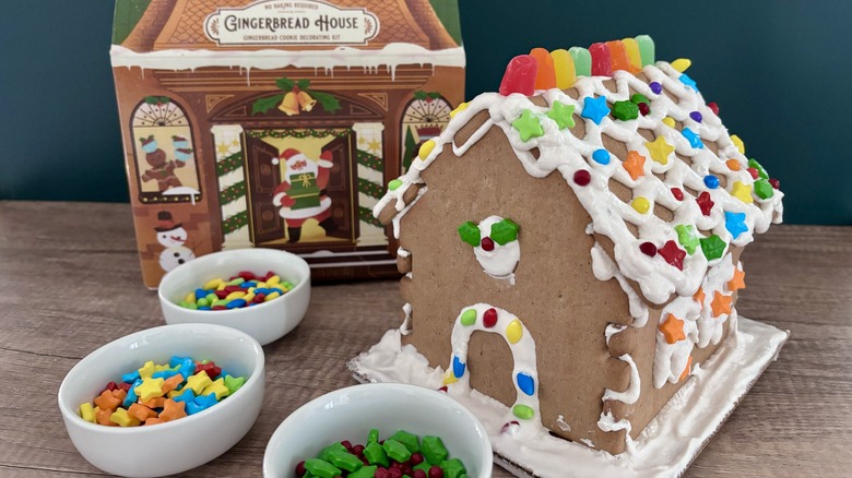 William Sonoma Gingerbread House next to bowls of decorations