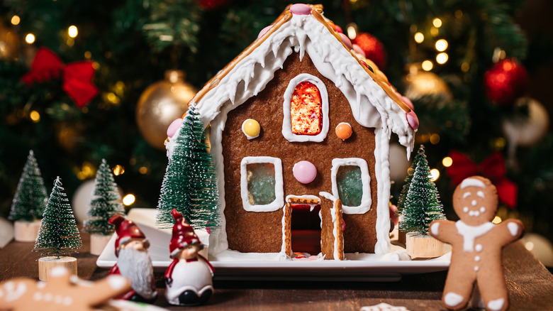 decorated gingerbread house with model trees and gingerbread figure
