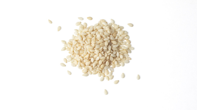 Pile of sesame seeds on white background