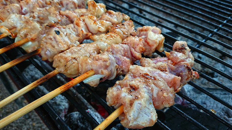 alligator meat grilling on skewers