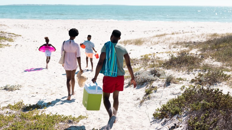 family walking onto beach