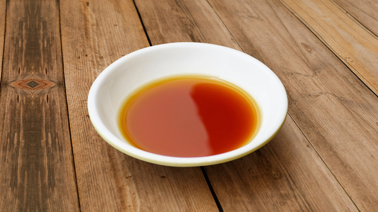 White bowl of fish sauce on table