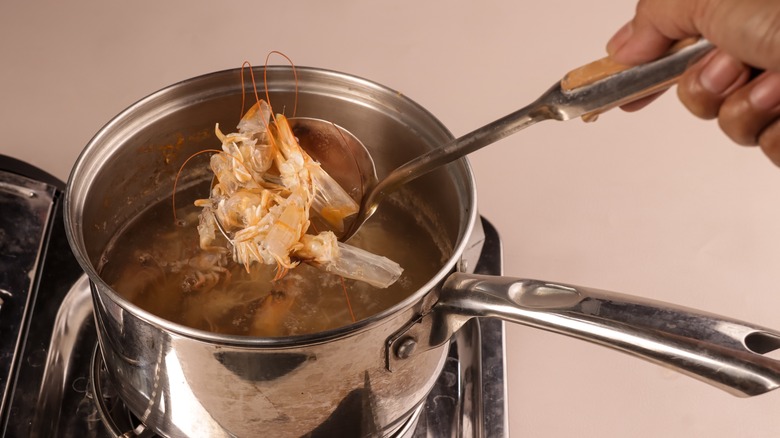 Person making shrimp stock in pot