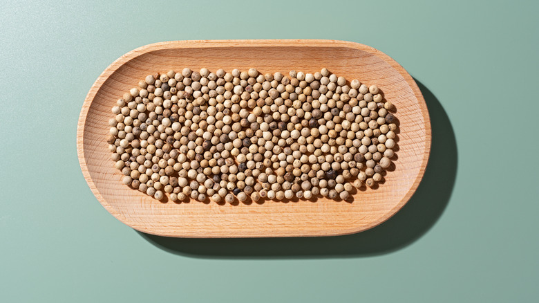 White pepper in wooden dish