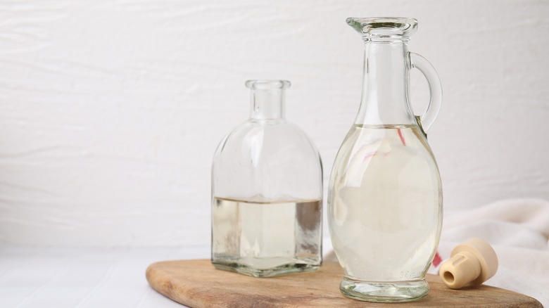 White vinegar in glass jug and bottle