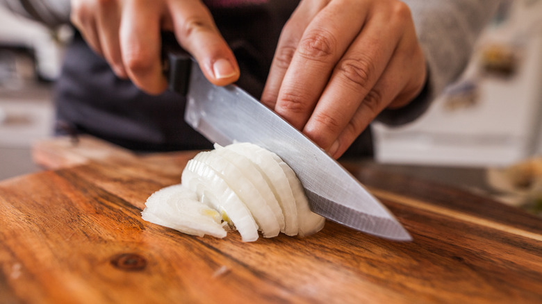 chef chopping a white onion