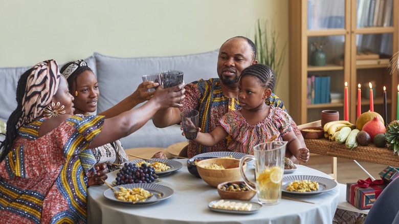 Family touching glasses Kwanzaa