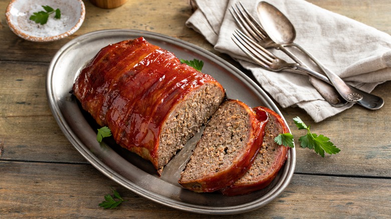 meatloaf half sliced with utensils