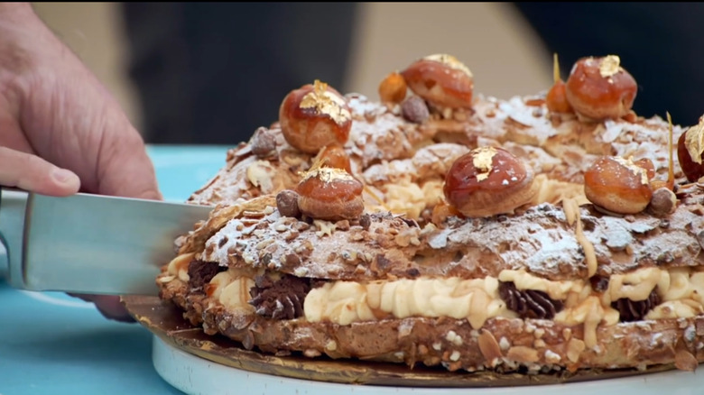 Paris-Brest being sliced with knife