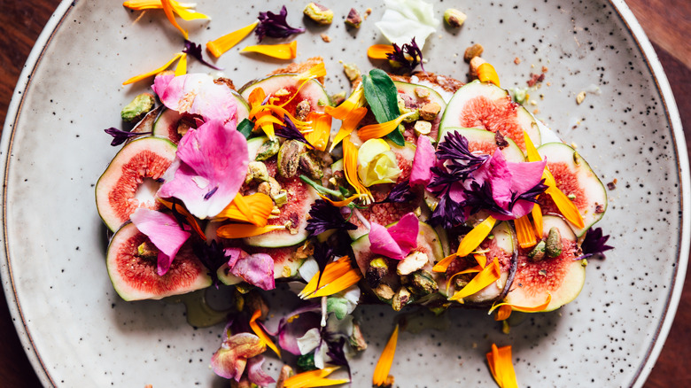 A colorful and textured unique salad featured on a gray plate.