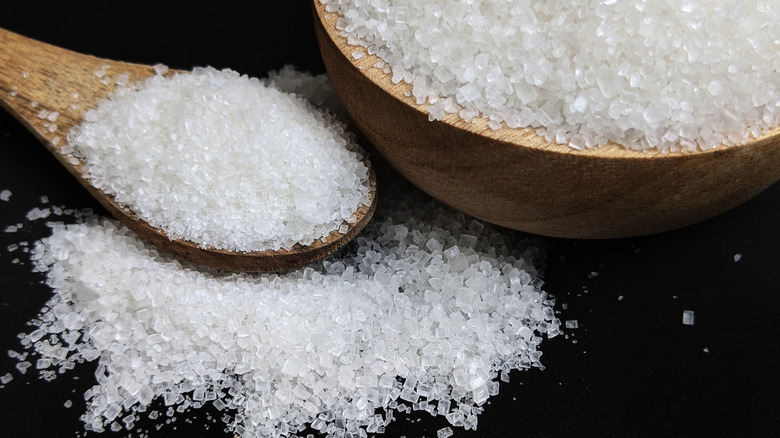 Granulated sugar in wooden bowl and spoon