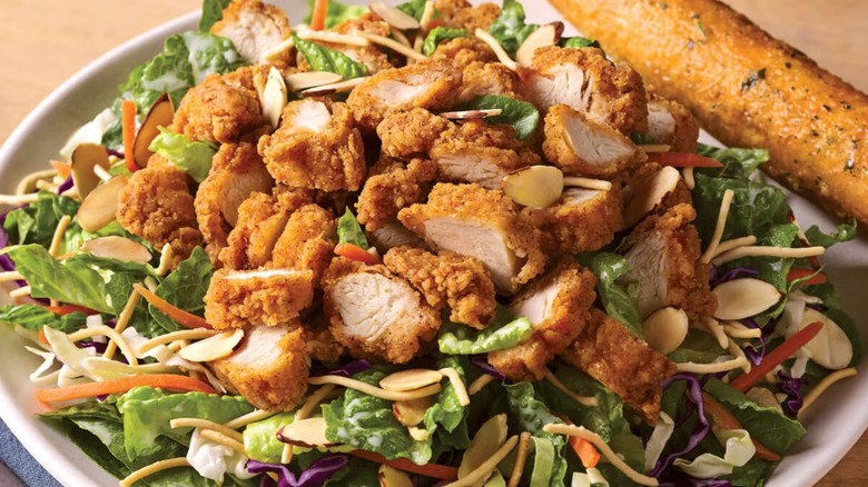 A plate of Applebee's oriental chicken salad with breadstick