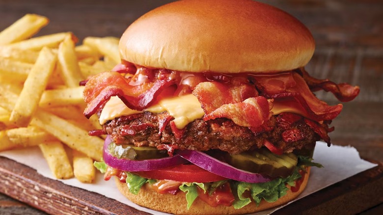 Applebee's Whole Lotta Bacon Burger with fries on wooden board