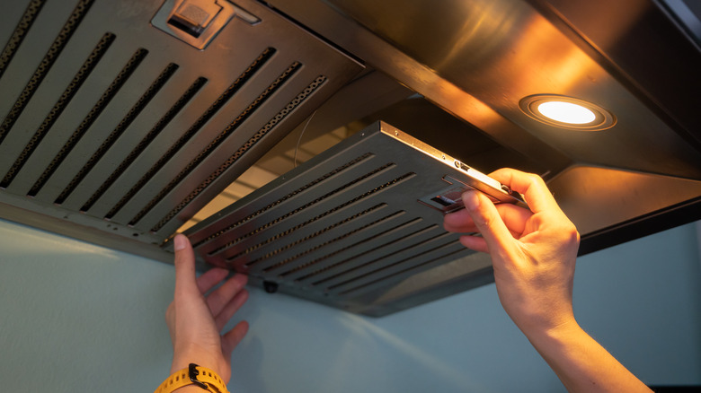 woman cleaning vent hood filters