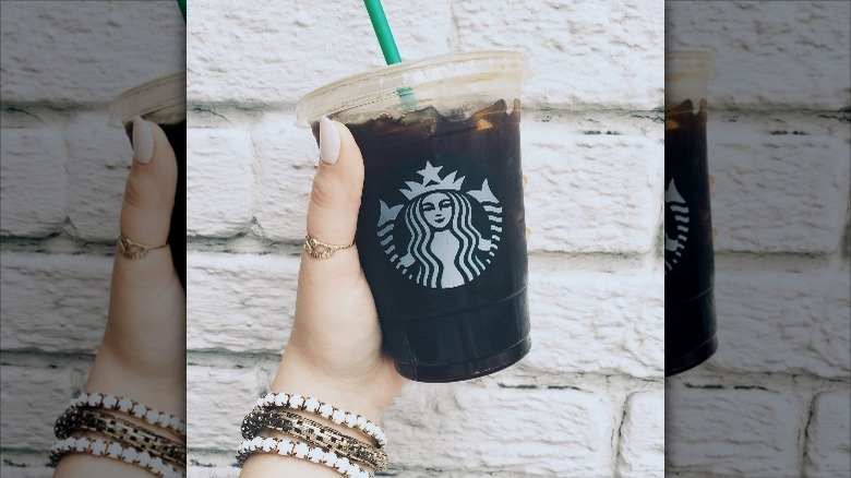 holding Starbucks iced americano